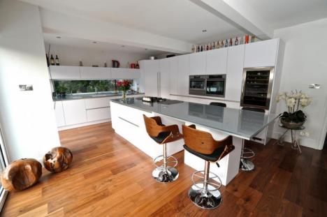 contemporary handleless white kitchen. Glass worktops. AEG appliances