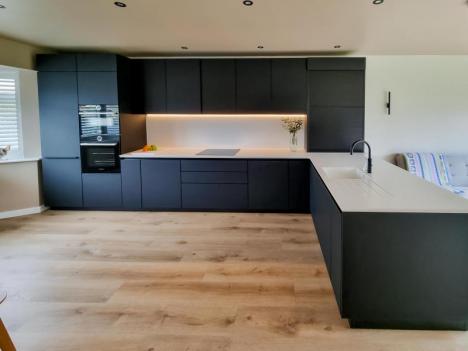 Handleless kitchen with Carbon Fenix® doors and Diore sorano solid surface tops