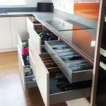 Kitchen hob run showing drawer storage finished in magnolia gloss underneath a grey quartz worktop