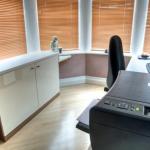 Office furniture and work surfaces custom fitted into a bay window area to make the fullest, neatest use of this space