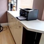 High gloss storage cupboards and worktops configured to fit the unusually shaped room.