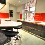 high gloss fitted kitchen with radius breakfast bar