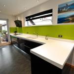 contemporary handleless fitted kitchen, Corian worktops, glass splashbacks