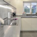Handleless Keller kitchen in gloss white with Corian® Lava Rock worktops