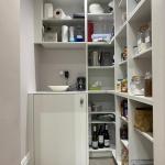 utility pantry with integrated washing machine and custom shelving