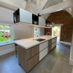 kitchen units in a mixture of gloss white and wood grain keep the look light but also warm