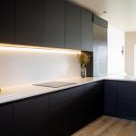 the worktop continues seamlessly up to the wall units for an elegant and hygienic finish