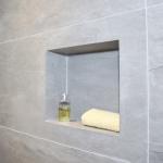 Bathroom niche shelf cut from porcelain tiles without trims for easier maintenance.