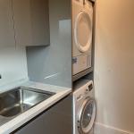 separate utility to match the kitchen, with stacked washing machine and tumble dryer