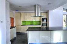 Handleless kitchen in vanilla gloss finish with stainless steel handle trims and Silestone quartz worktops