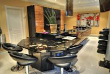 Dining table end of the kitchen island with black galaxy granite worktop and four black stools