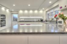 Handleless Keller kitchen in gloss white with Corian® Lava Rock worktops