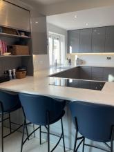 kitchen with glossy grey units and white and grey solid surface worktops